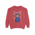 A holiday sweatshirt featuring a cute Grim Reaper holding a scythe, wearing a Santa hat. Above the character is the text "Grave Tidings We Bring," surrounded by festive snowflakes and holiday-themed designs. The combination of spooky and festive elements adds a humorous twist to traditional holiday attire.